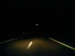 Foto genomen in een wagen 's nachts: je ziet alleen wat licht van de koplampen en het licht van de straatverlichting